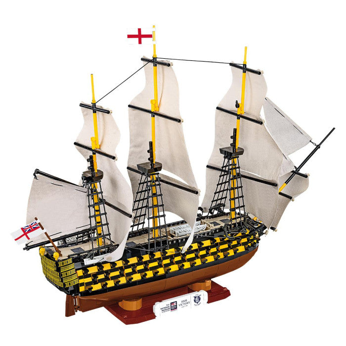 Model ship with white sails and yellow accents on a white background