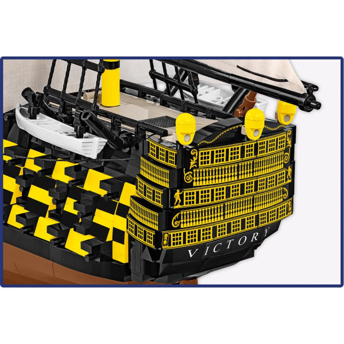 Model ship with yellow details and 'VICTORY' inscription on a white background