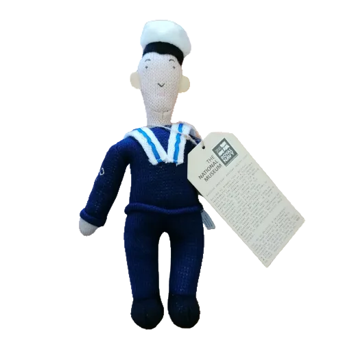 Knitted toy of a sailor with a tag on a white background