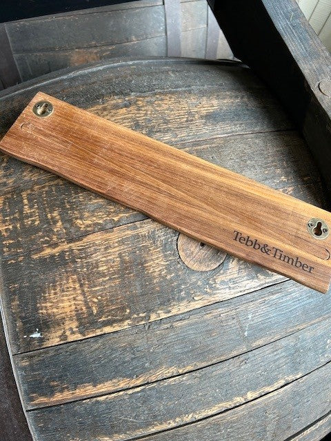 Wooden magnetic knife holder with 'Tebb & Timber' branding on a rustic wooden surface