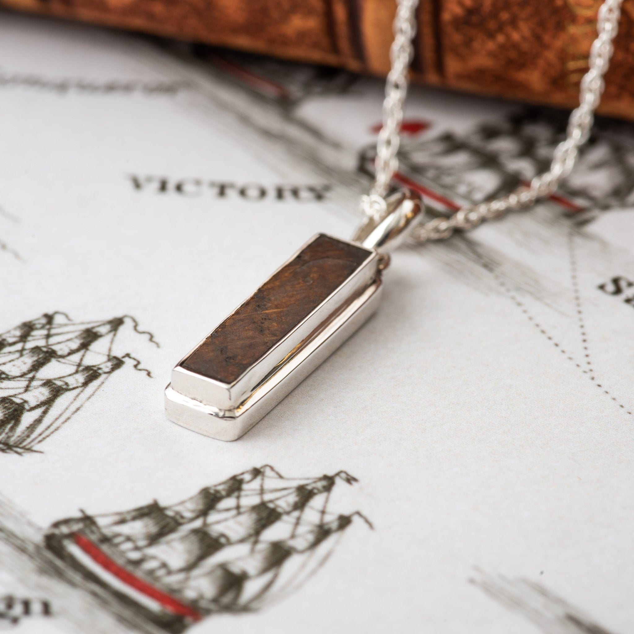 Wooden pendant on a silver chain on a map background