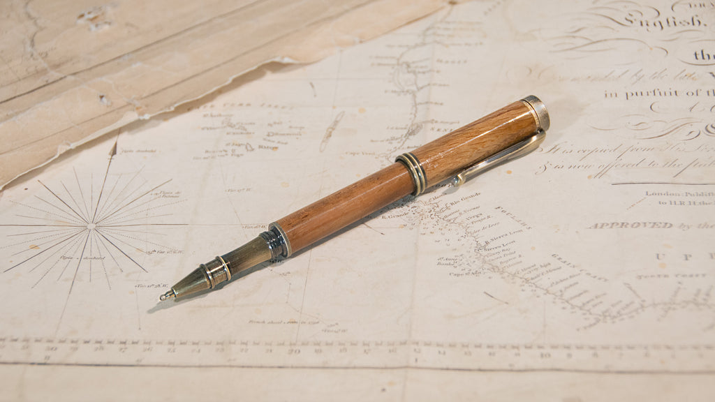 A wooden ballpoint pen with an antique brass finished tip