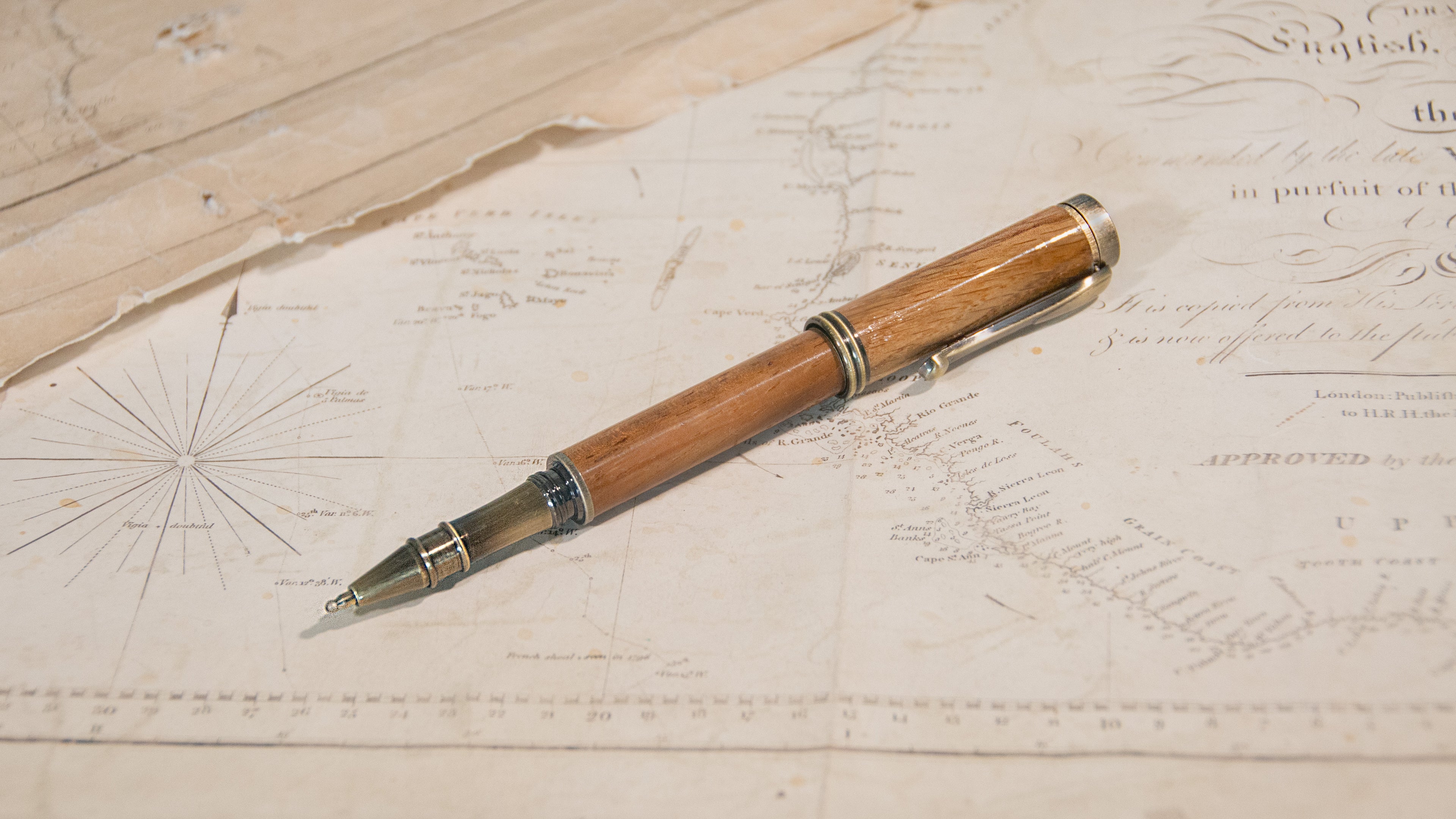 A wooden ballpoint pen with an antique brass finished tip