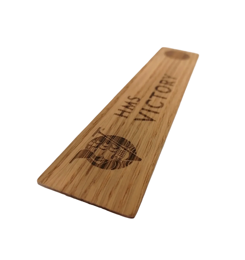 A flat piece of wood featuring timber removed during the restoration of HMS Victory, once part of the ship herself. It has the words HMS Victory marked on it.