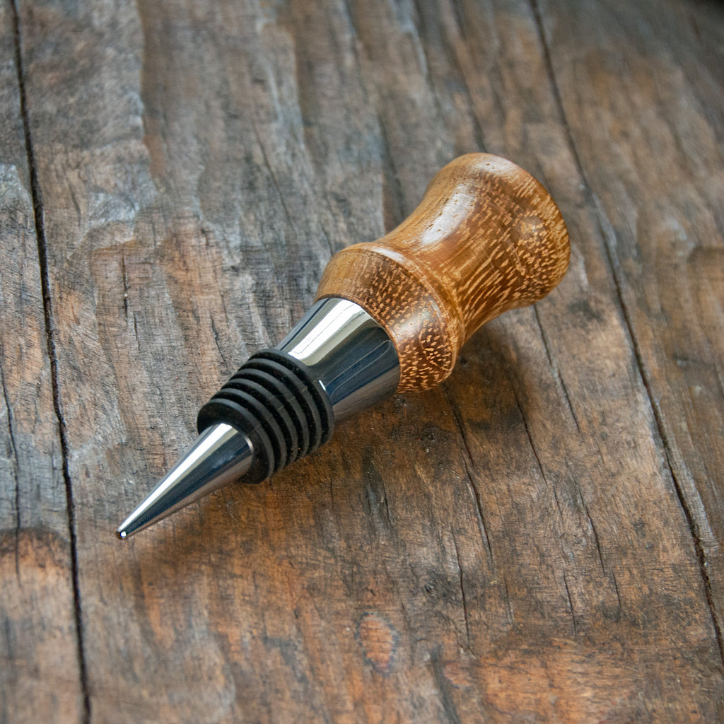 a modern stainless steel bottle stopper, with a handle made of oak.