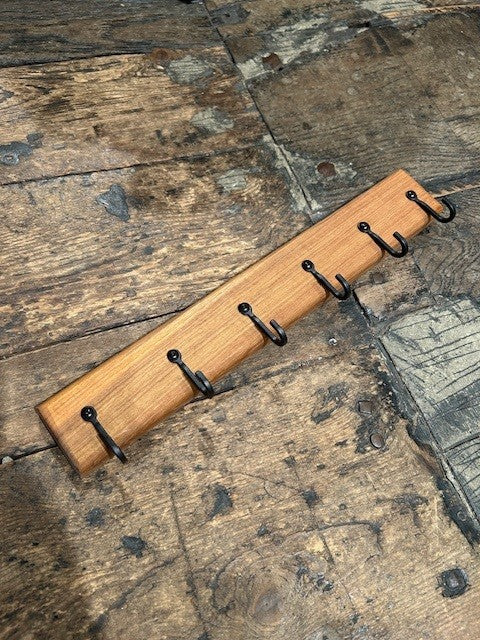 Wooden rack with six hooks on a rustic wooden floor