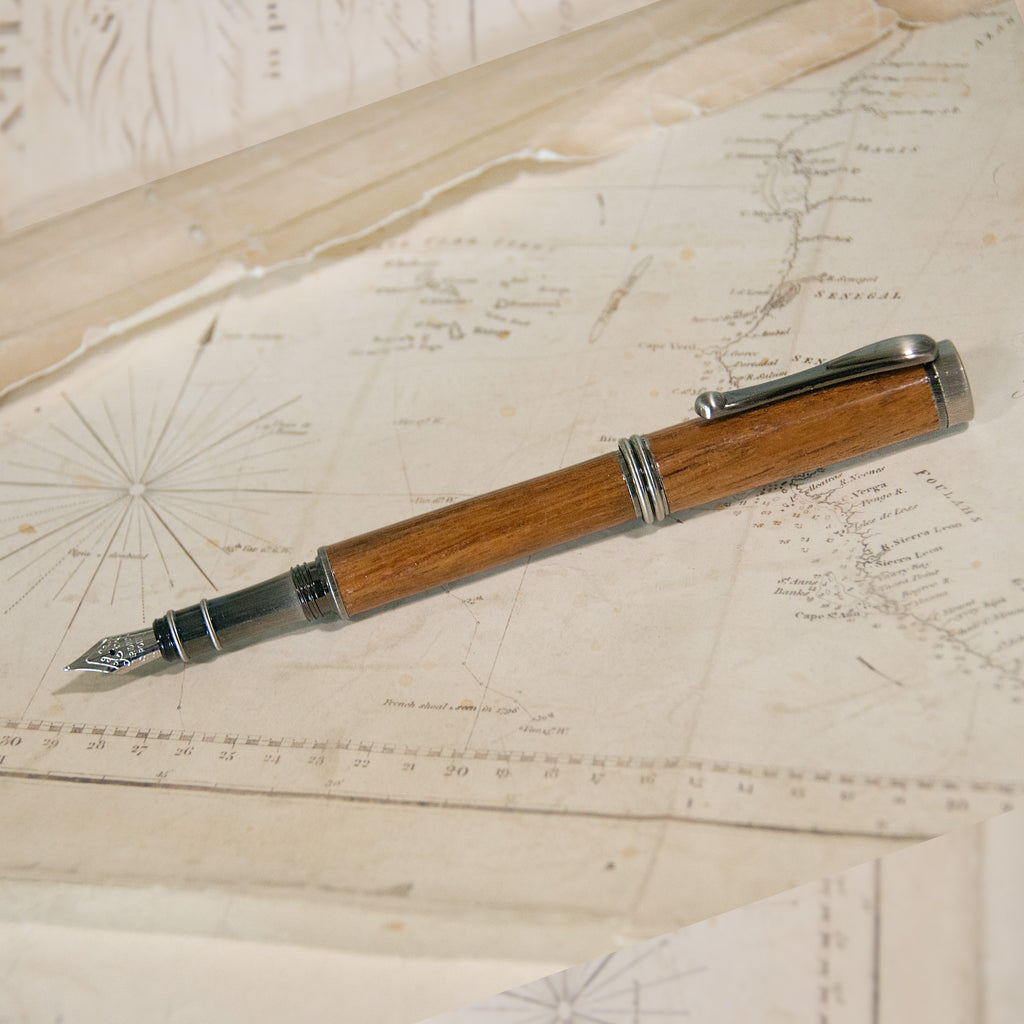 a wooden fountain pen with an antique brass tip