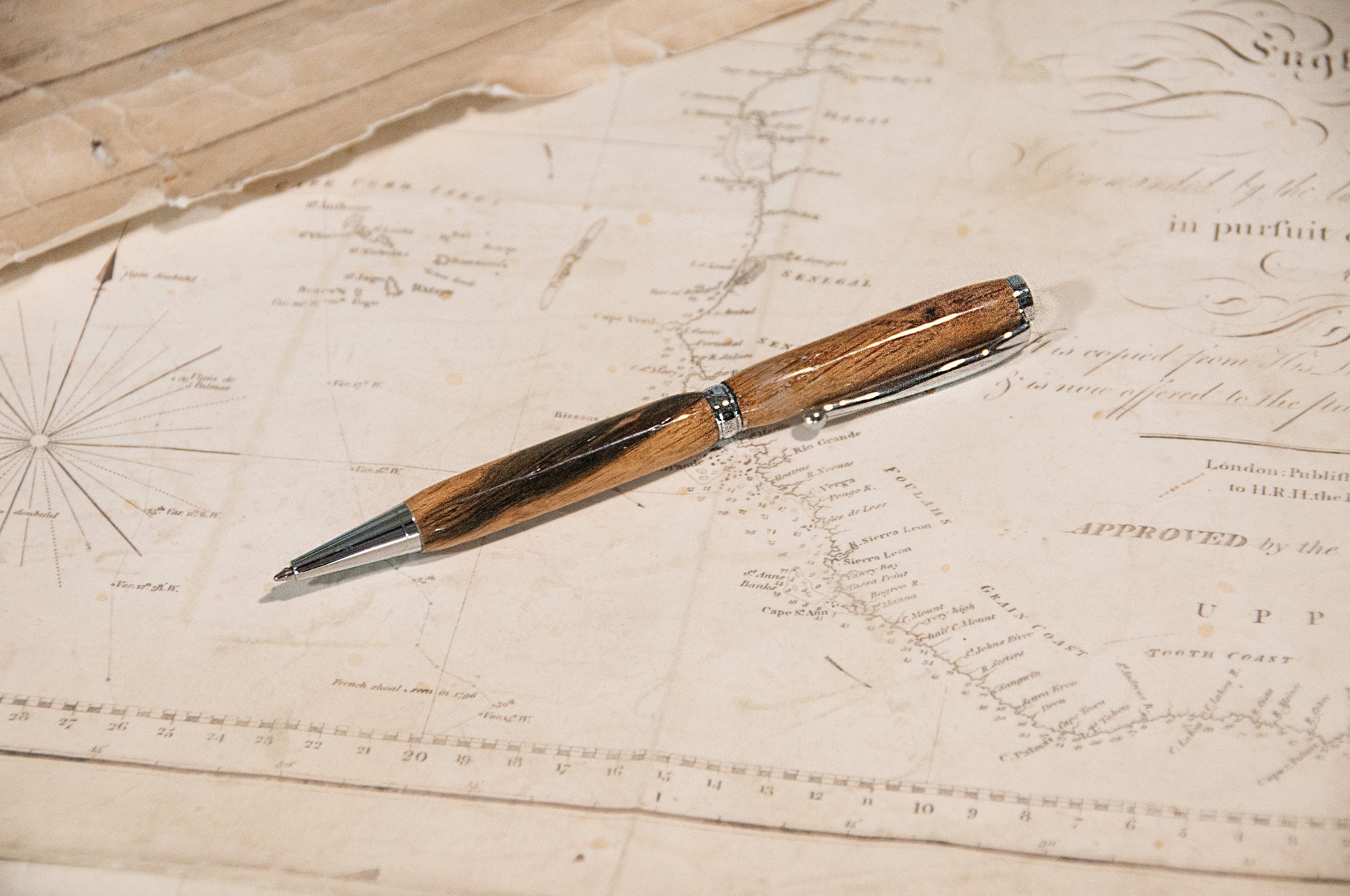 Wooden pen on an old document with map-like text