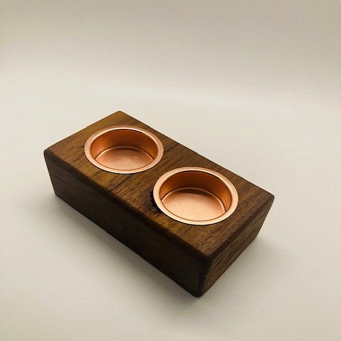 Wooden block with two copper bowls on a beige background