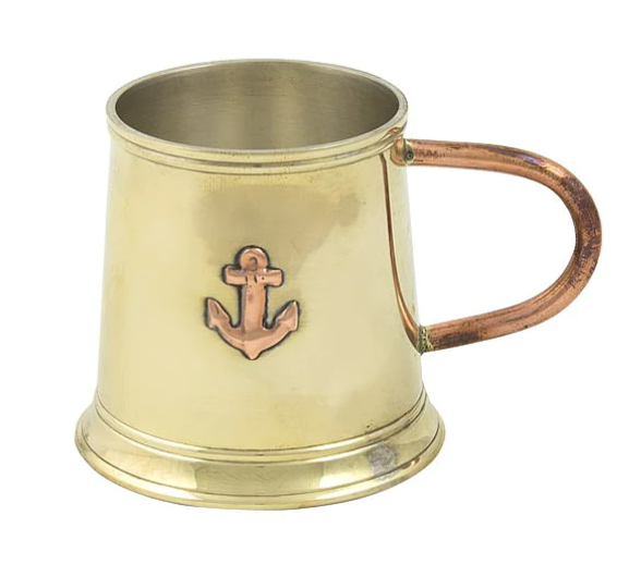 Brass mug with a copper anchor emblem on a white background