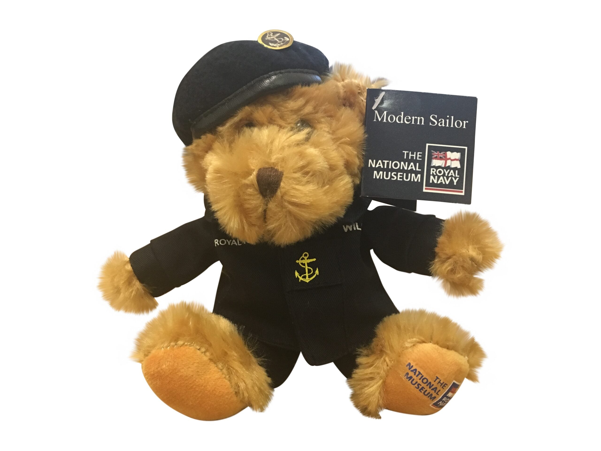 Plush teddy bear in a navy blue outfit with a cap.