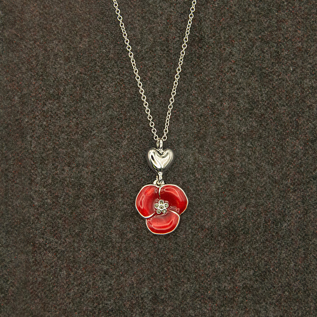 Necklace with a silver heart and red poppy flower pendant.