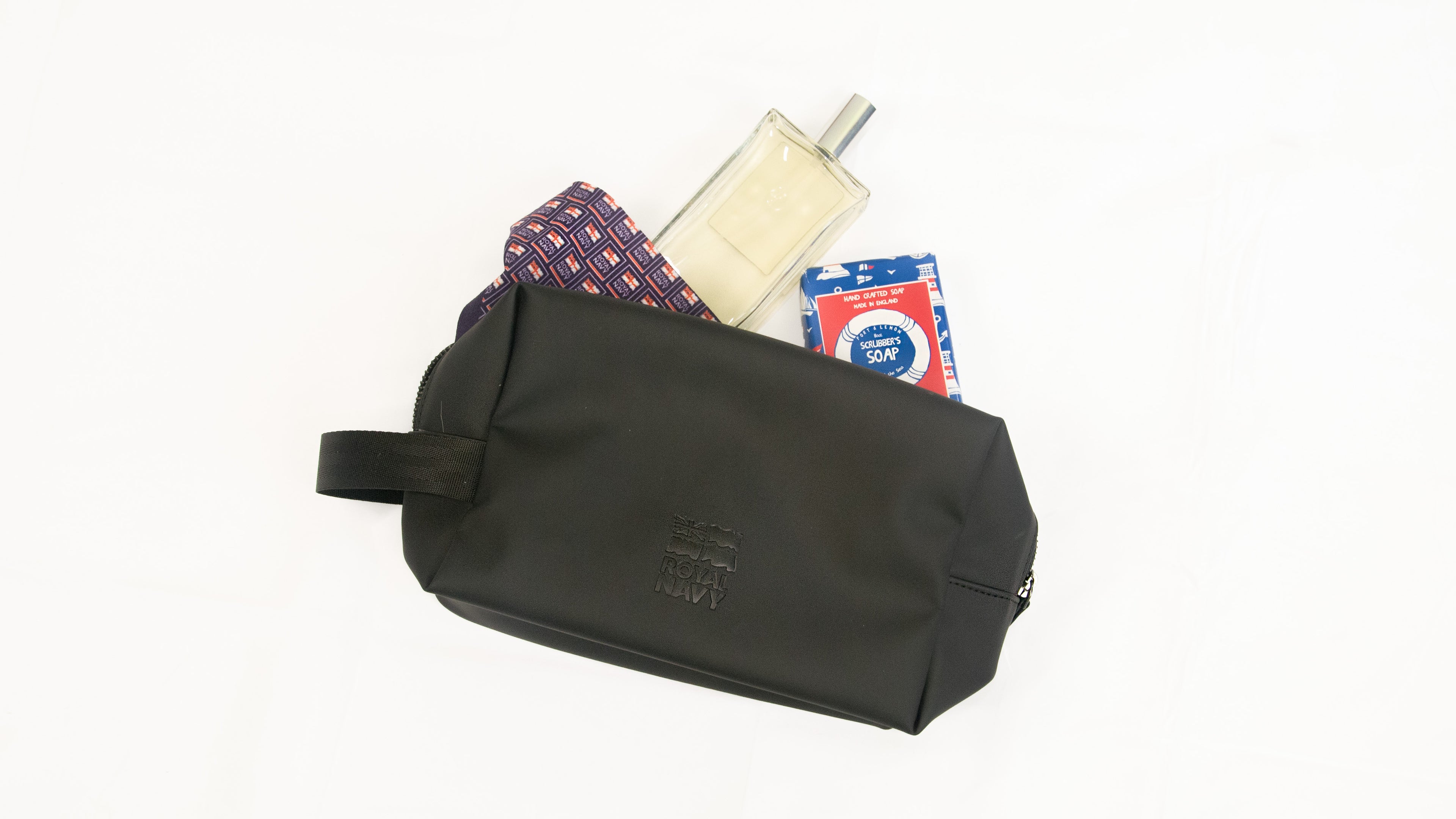 Black toiletry bag with travel items on a white background, and Royal Navy embossing