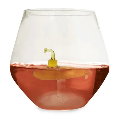 Clear glass with a small yellow glass submarine apparently floating on rose-coloured liquid
