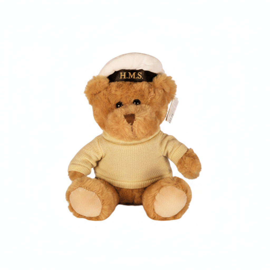 Teddy bear wearing a beige submariner's sweater and cap on a white background