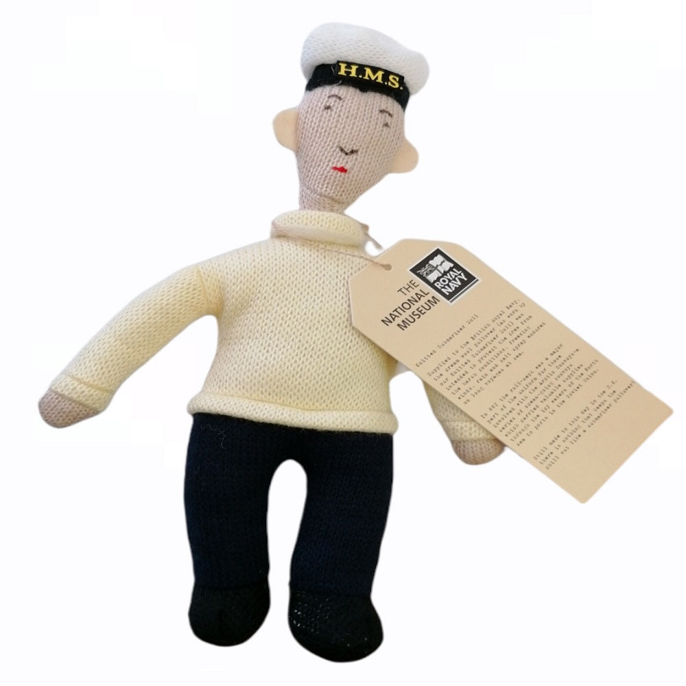 Knitted sailor doll with a tag on a white background